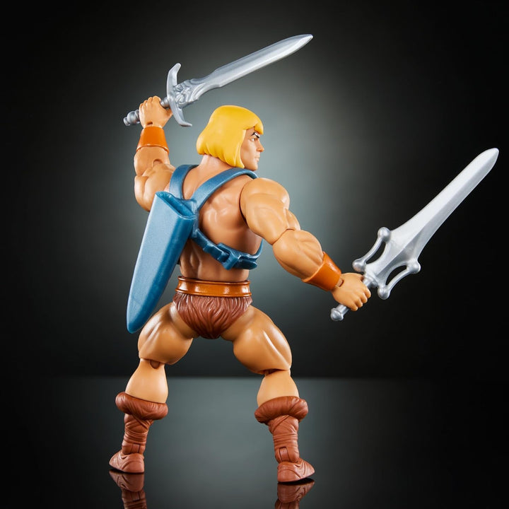 Jucărie Masters of the Universe Origins, He-Man figurină de acțiune din colecția de desene animate, la scară reală, aprox. 14 cm înălțime, erou cu armură, 2 săbii și mini benzi desenate, HYD17